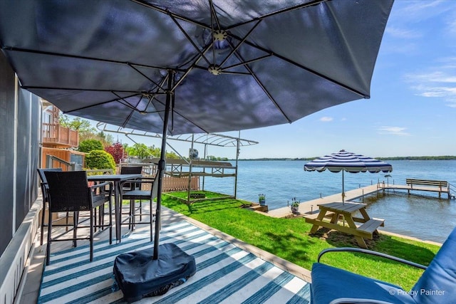 view of patio / terrace featuring a water view, a boat dock, and outdoor dining area