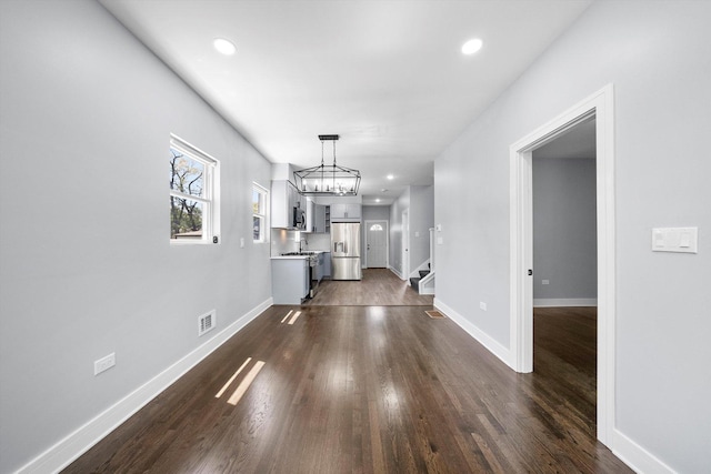 7414 S Aberdeen St, Chicago, IL 60621 - unfurnished living room with dark wood-style floors, a chandelier, baseboards, recessed lighting, and stairs