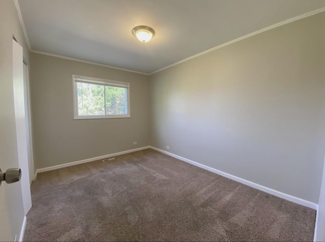 unfurnished room with ornamental molding, dark carpet, and baseboards