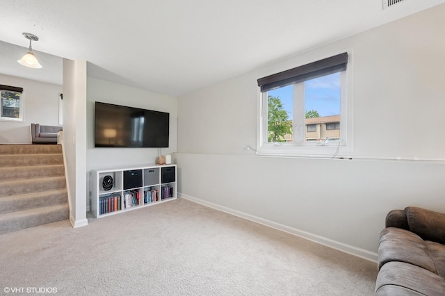 living area featuring carpet, healthy amount of natural light, baseboards, and stairs