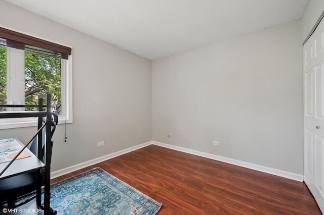 unfurnished office with wood finished floors and baseboards