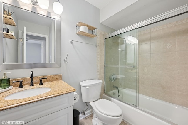 bathroom with vanity, shower / bath combination with glass door, toilet, and baseboards