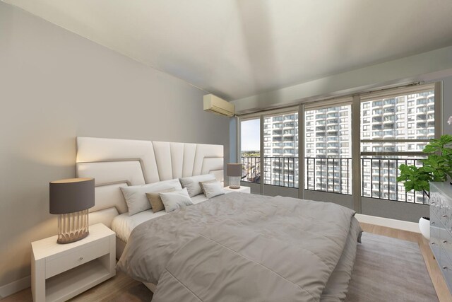 bedroom featuring a wall mounted AC, access to exterior, wood finished floors, and baseboards
