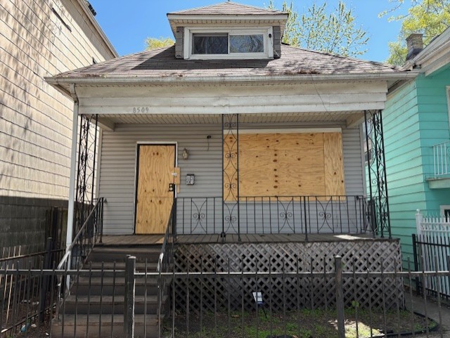 8509 S Muskegon Ave, Chicago, IL 60617 - shotgun-style home with a porch, fence, and roof with shingles