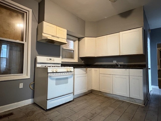 8509 S Muskegon Ave, Chicago, IL 60617 - kitchen with gas range gas stove, white cabinetry, dark wood-style flooring, and extractor fan