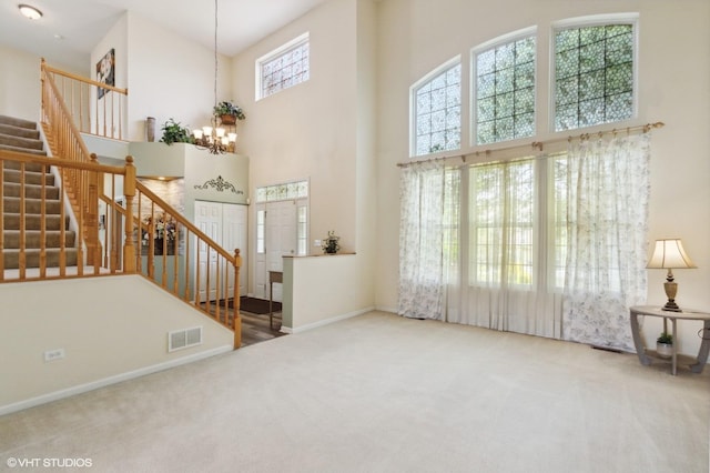 1701 Wintercrest Ln, Shorewood, IL 60404 - unfurnished living room featuring a high ceiling, carpet, a chandelier, stairway, and baseboards
