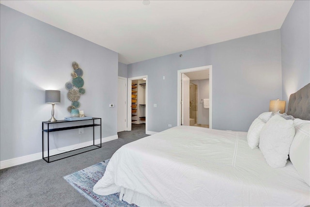 bedroom with carpet floors, baseboards, a walk in closet, and connected bathroom