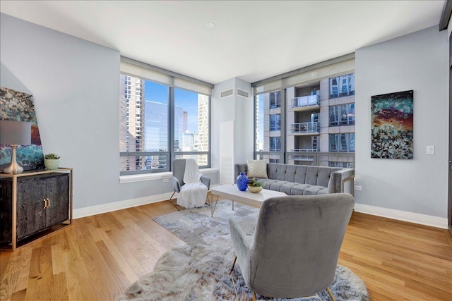 sitting room featuring baseboards, wood finished floors, and a view of city
