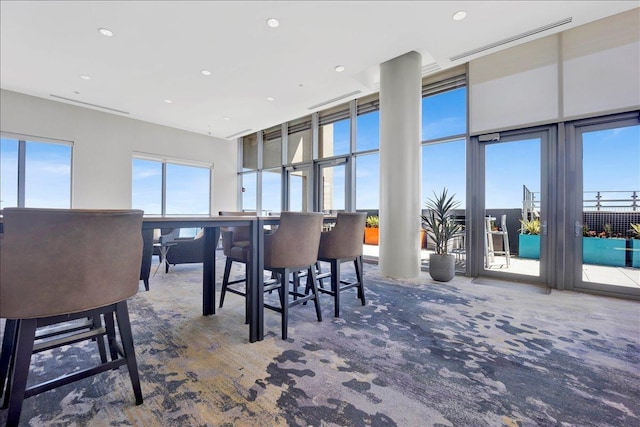 carpeted dining area with recessed lighting and a towering ceiling