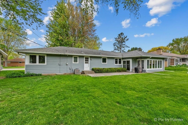 back of property featuring central AC, a lawn, a chimney, and a patio