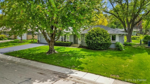 obstructed view of property with driveway, a front lawn, and an attached garage
