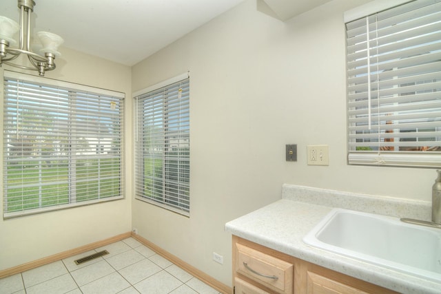 bathroom with tile patterned flooring, a sink, baseboards, and a chandelier