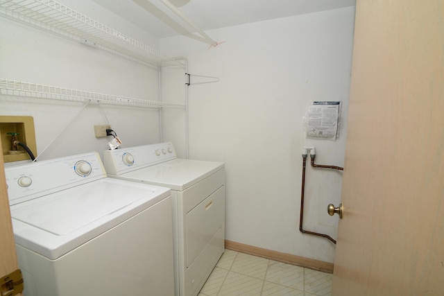 washroom with independent washer and dryer and baseboards