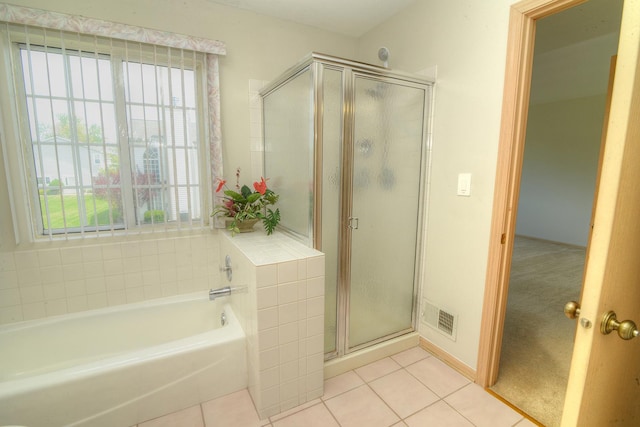 full bath featuring healthy amount of natural light, tile patterned flooring, and a shower stall