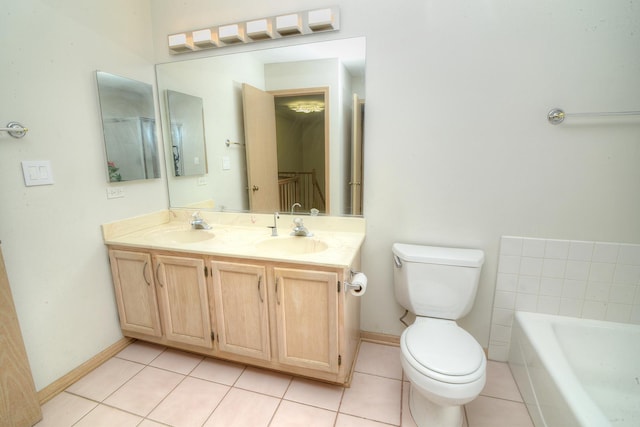 full bath with toilet, double vanity, a bathtub, and baseboards