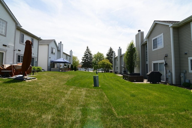 view of grassy yard with a gazebo and a residential view