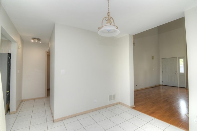 unfurnished room featuring baseboards and light tile patterned floors