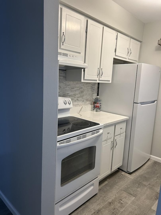 kitchen with white appliances, under cabinet range hood, tasteful backsplash, wood finished floors, and white cabinets