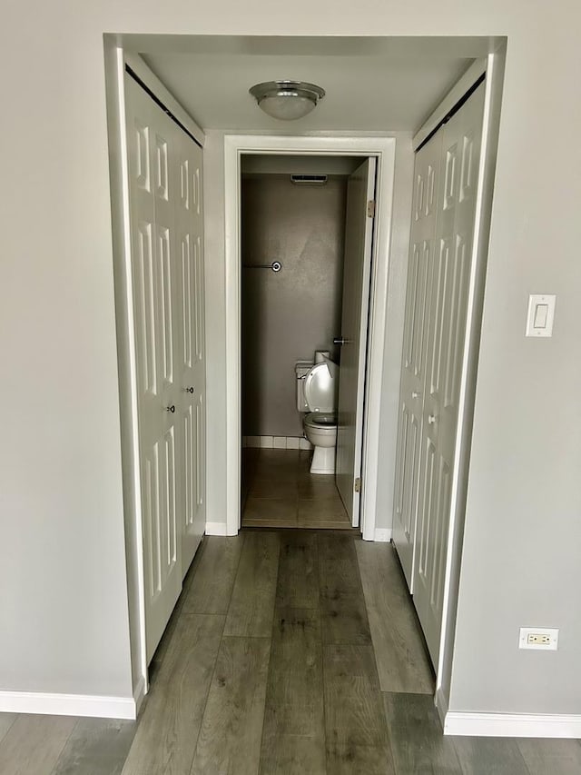 hallway with baseboards and wood finished floors