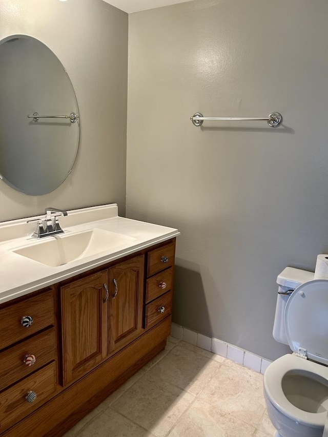 bathroom featuring tile patterned flooring, vanity, toilet, and baseboards