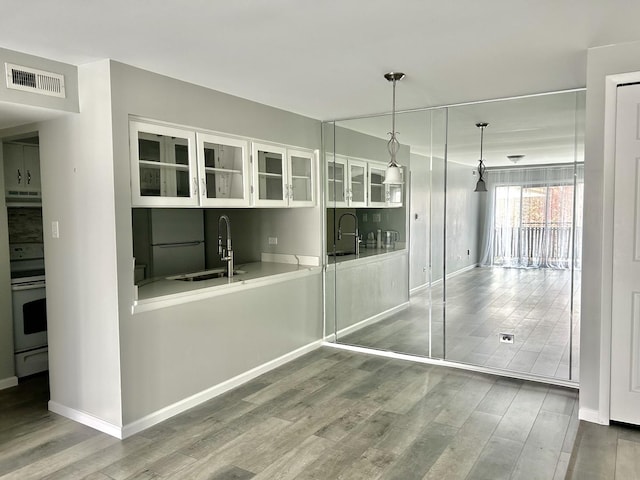 unfurnished dining area featuring a sink, wood finished floors, and baseboards