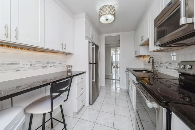 4800 S Chicago Beach Dr Unit 1007N, Chicago, IL 60615 - kitchen with appliances with stainless steel finishes, a sink, dark stone counters, backsplash, and light tile patterned floors