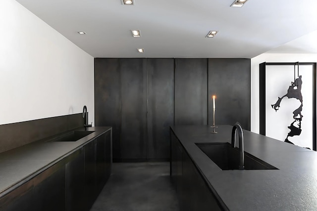 3845 S Winchester Ave, Chicago, IL 60609 - kitchen with a sink, concrete floors, modern cabinets, dark cabinetry, and dark countertops