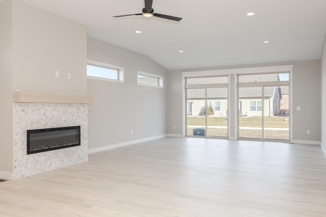 1904 Dunraven Rd, Bloomington, IL 61704 - unfurnished living room featuring ceiling fan, light wood-style floors, vaulted ceiling, baseboards, and a glass covered fireplace