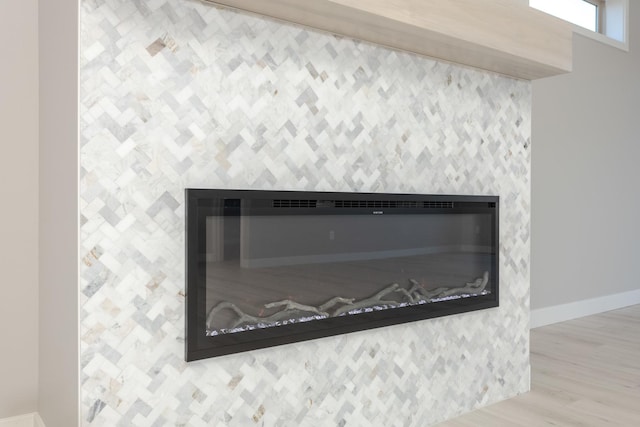 1904 Dunraven Rd, Bloomington, IL 61704 - detailed view of a glass covered fireplace, baseboards, and wood finished floors