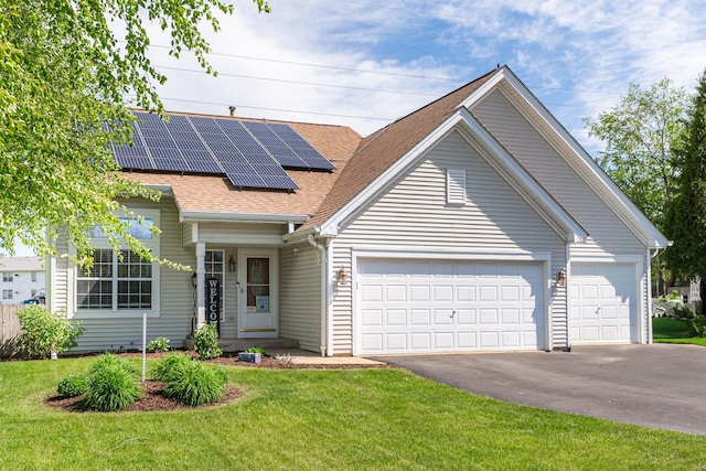 2124 Northwood Dr, Belvidere, IL 61008 - view of front facade featuring asphalt driveway, a garage, a front yard, solar panels, and a shingled roof
