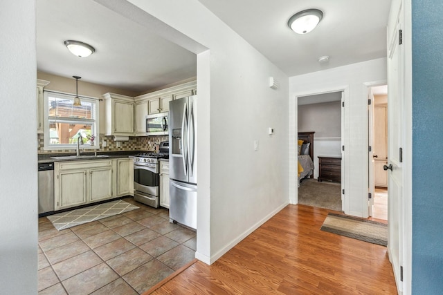 2124 Northwood Dr, Belvidere, IL 61008 - kitchen with appliances with stainless steel finishes, a sink, dark countertops, backsplash, and hanging light fixtures