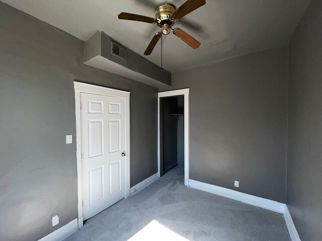 12256 S Union Ave, Chicago, IL 60628 - unfurnished bedroom featuring carpet flooring, baseboards, a closet, and a ceiling fan