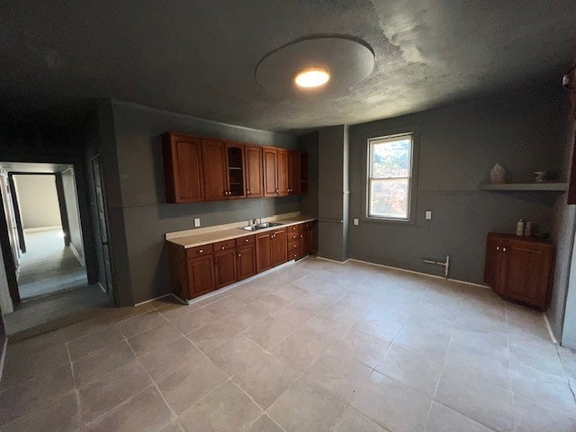 12256 S Union Ave, Chicago, IL 60628 - kitchen featuring a sink, light countertops, brown cabinetry, and light tile patterned flooring