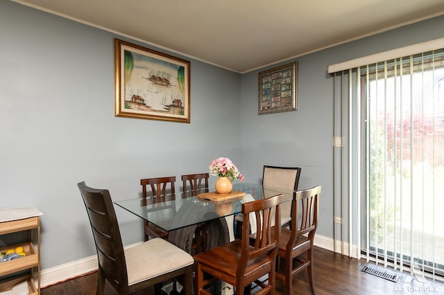 dining space featuring ornamental molding, baseboards, and dark wood-type flooring