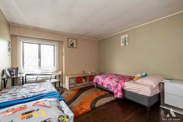 bedroom with wood finished floors and crown molding
