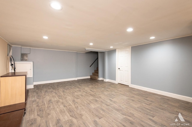 finished below grade area featuring recessed lighting, wood finished floors, stairway, and baseboards