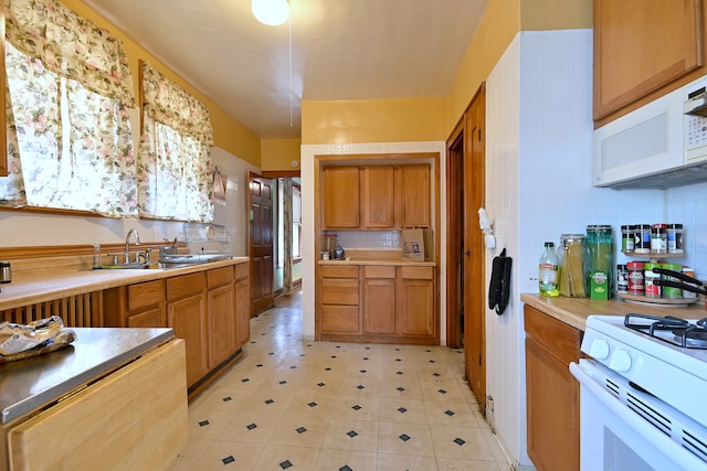 3113 N Major Ave, Chicago, IL 60634 - kitchen with white appliances, a sink, brown cabinetry, light countertops, and backsplash