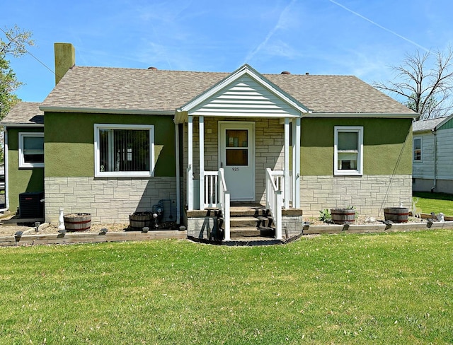 925 N Otter Creek Rd, Streator, IL 61364 - bungalow featuring stone siding, a front lawn, roof with shingles, and stucco siding