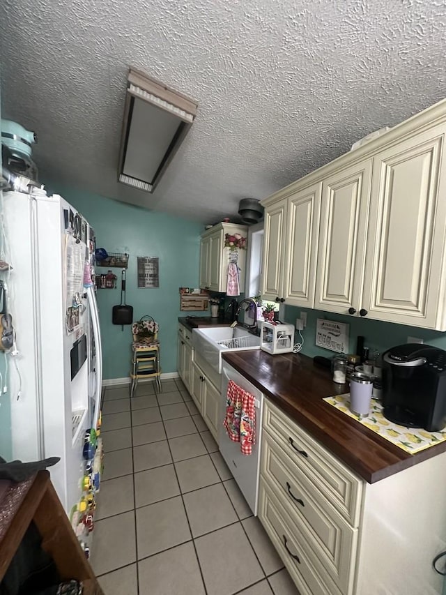 795 N Erie St, Braidwood, IL 60408 - kitchen with cream cabinetry, butcher block counters, light tile patterned flooring, white fridge with ice dispenser, and stainless steel dishwasher