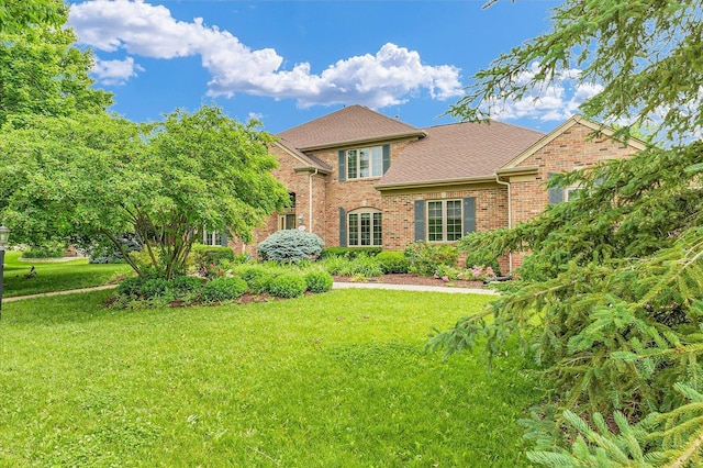 4410 Southford Trace Dr, Champaign, IL 61822 - view of front of house with brick siding, a front yard, and roof with shingles