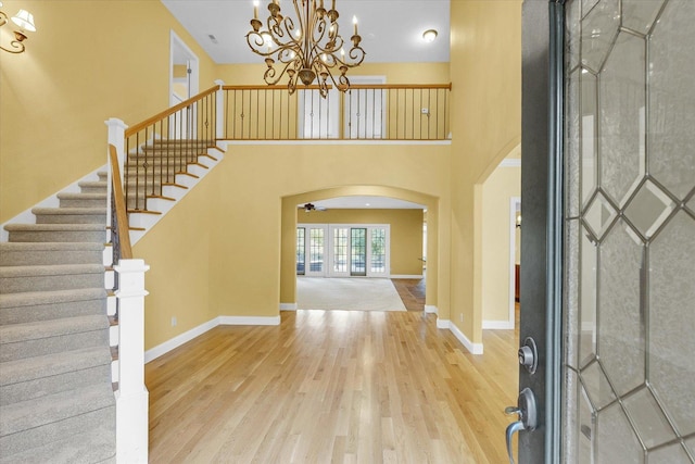 4410 Southford Trace Dr, Champaign, IL 61822 - entryway featuring arched walkways, wood finished floors, a chandelier, stairs, and a high ceiling