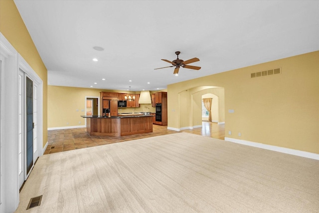 4410 Southford Trace Dr, Champaign, IL 61822 - kitchen with open floor plan, arched walkways, dark countertops, premium range hood, and black microwave