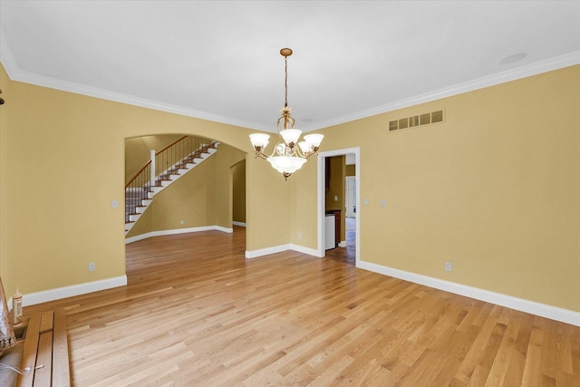 4410 Southford Trace Dr, Champaign, IL 61822 - unfurnished room with arched walkways, a chandelier, light wood-style flooring, crown molding, and baseboards