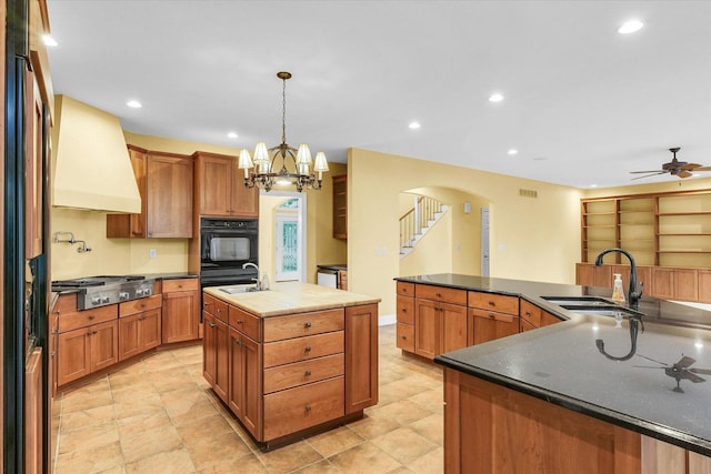 4410 Southford Trace Dr, Champaign, IL 61822 - kitchen with stainless steel gas cooktop, a large island with sink, a sink, premium range hood, and arched walkways