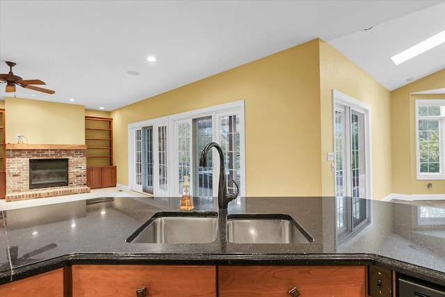 4410 Southford Trace Dr, Champaign, IL 61822 - kitchen featuring a sink, open floor plan, dark stone counters, a brick fireplace, and lofted ceiling