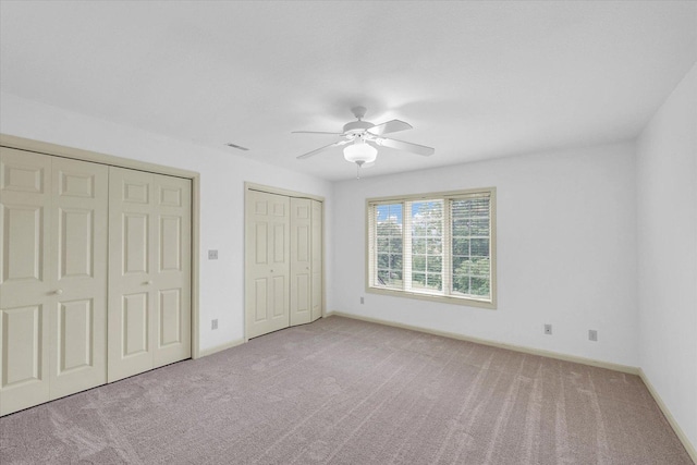 4410 Southford Trace Dr, Champaign, IL 61822 - unfurnished bedroom with multiple closets, carpet, baseboards, and a ceiling fan