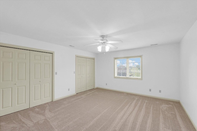 4410 Southford Trace Dr, Champaign, IL 61822 - unfurnished bedroom featuring multiple closets, carpet floors, baseboards, and ceiling fan