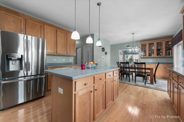 9 Laurel Valley Ct, Lake In The Hills, IL 60156 - kitchen featuring stainless steel fridge with ice dispenser, light wood-style flooring, brown cabinetry, a center island, and hanging light fixtures