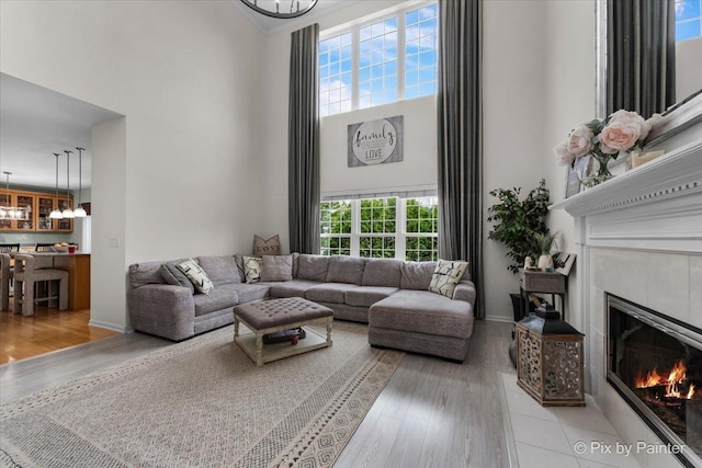 9 Laurel Valley Ct, Lake In The Hills, IL 60156 - living area with a towering ceiling, a chandelier, wood finished floors, and a glass covered fireplace