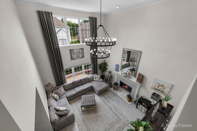 9 Laurel Valley Ct, Lake In The Hills, IL 60156 - living room with a chandelier, a towering ceiling, ornamental molding, and a lit fireplace